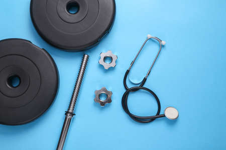 Health and fitness concept. Barbell with a stethoscope on a blue background. Top viewの写真素材