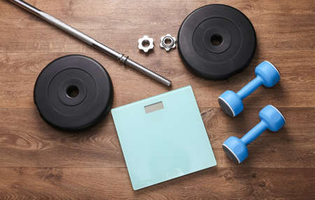 Bodybuilding and fitness. Losing weight or gaining muscle mass. Barbell with dumbbells  and scales...