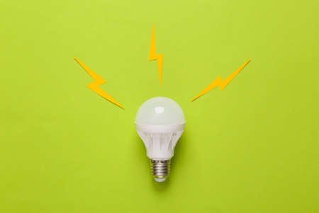 Led light bulb with sparks on a green background. Creative idea conceptの写真素材