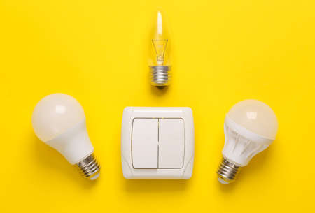 Light switch and led light bulbs on a yellow background. Top view