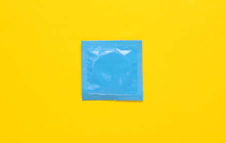 Blue condom packaging on a yellow background. Top viewの写真素材