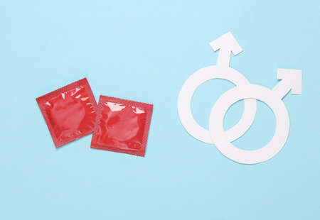 Same-sex relationship concept. Condoms, two male symbols on a blue background. Top viewの写真素材