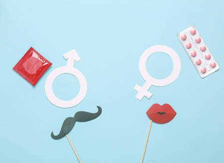 Contraception concept, safe sex, birth control/ Male and female gender symbol, mustache and lips on a stick, birth control pills and condomsの写真素材