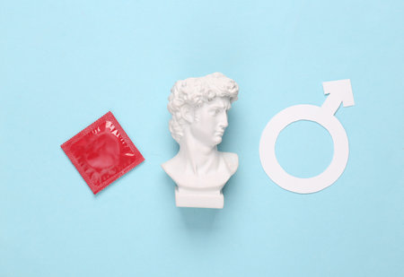 Condom with male gender symbol and david bust on blue backgroundの写真素材
