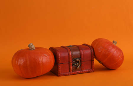 Halloween still life. Pirate chest with pumpkins on orange backgroundの写真素材