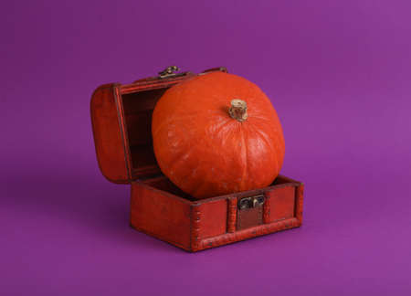 Halloween still life. Pirate chest with pumpkin on purple backgroundの写真素材