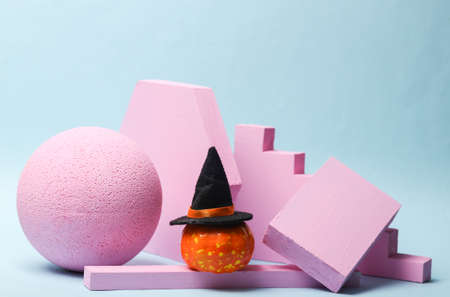 Geometric showcase with Halloween pumpkin in a hat on a blue background. Minimal halloween still...