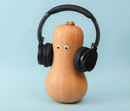Pumpkin with eyes and stereo headphones on a blue background.の写真素材