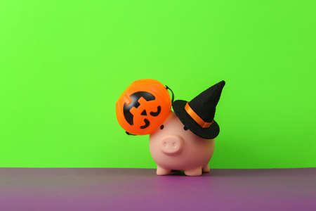 Gift box with halloween buckets and witch hat on green purple background. creative halloween layoutの写真素材
