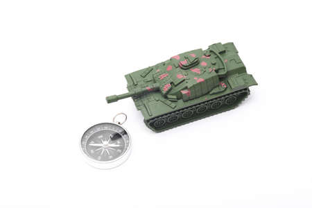 Plastic toy tank with compass on white backgroundの写真素材