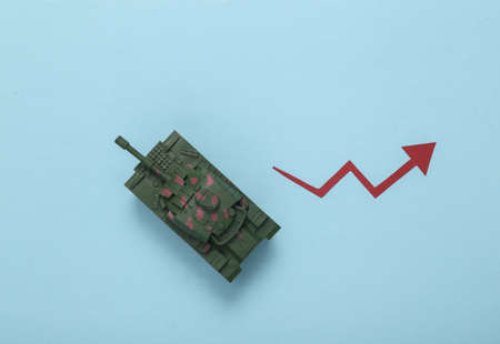 Toy tank with growth arrow on blue backgroundの写真素材