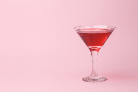 Martini glass with red drink cocktail on pink backgroundの写真素材