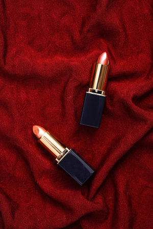 Lipstick tubes on red crumpled silk backgroundの写真素材