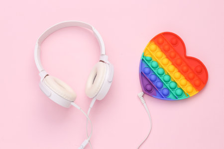 Headphones with antistress pop it toy on pink backgroundの写真素材