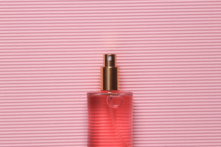 Pink perfume bottle on pink background