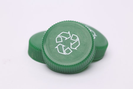 Plastic bottle caps with recycle symbol on white background. Eco concept