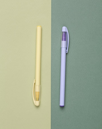 Two pens on green background. Minimal still life