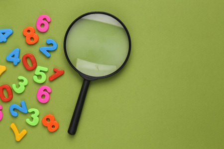 Loupe with many numbers on a green backgroundの写真素材