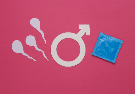 contraception. Condom package and spermatozoa with gender male symbol on pink background. top viewの写真素材