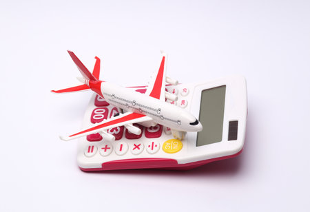 Calculator with a model of a passenger plane on a white background. travel concept