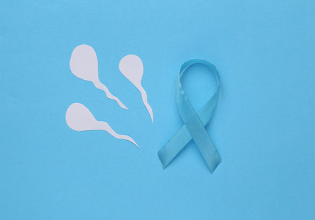 Blue ribbon as symbol of prostate cancer awareness and male semen(spermatozoa) on a blue backgroundの写真素材