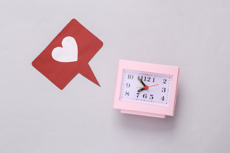 Clock with like icon on gray background