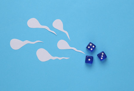 Reproduction concept. Male seed (spermatozoa) with dice, blue background