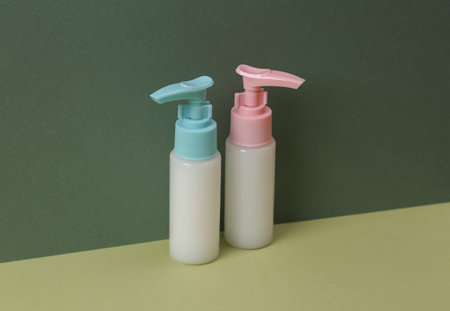 Aesthetic beauty still life. Bottles of cream or liquid soap on two tone green background.の写真素材