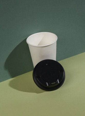 Take away white coffee cup on two tone green background with shadow. creative composition. food and drinkの写真素材