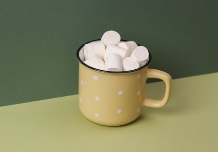 Cup with marshmallows on a green two-tone background. Minimal still lifeの写真素材