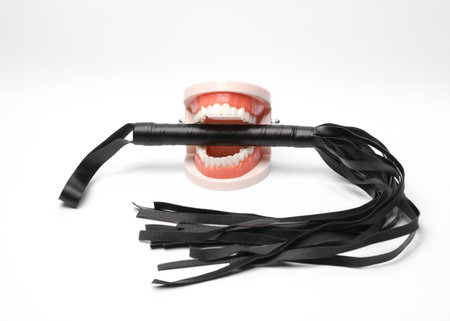 Jaw with leather whip on white background. Bdsm, dominance, sex gamesの写真素材