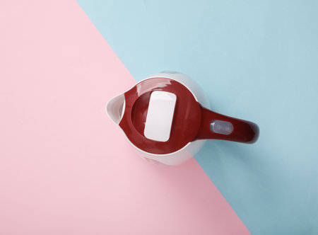 Plastic electric kettle on a blue-pink pastel background. top viewの写真素材