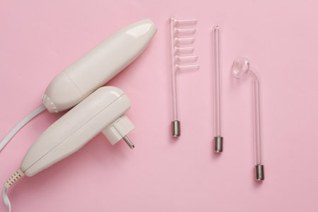 Device for local darsonvalization on pink background. Treatment of acne, problem skin. top view....