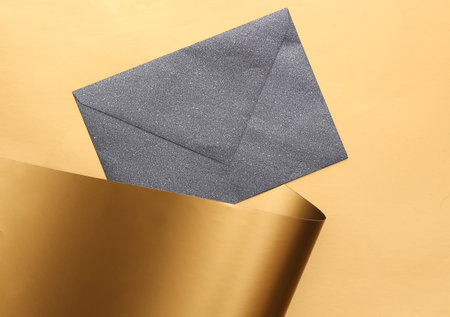 Black envelope on a luxurious golden backgroundの写真素材