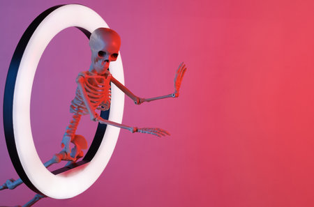 Scary skeleton through led ring lamp in red blue neon gradient light. creative ideas. halloween conceptの写真素材