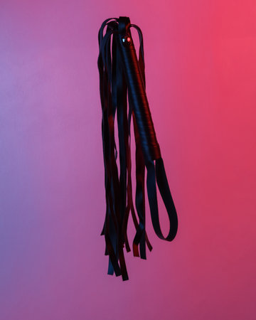 Sex shop leather whip floating in the air, isolated in blue-red neon gradient light. levitating objects. Minimal conceptの写真素材