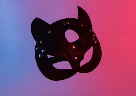 Sex shop leather cat mask floating in the air, isolated in blue-red neon gradient light. levitating objects. minimal concept. sex gamesの写真素材