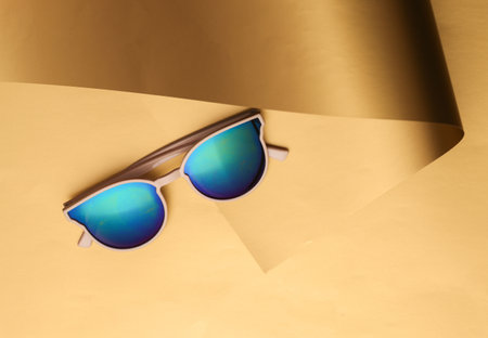 Sunglasses on a luxurious golden backgroundの写真素材