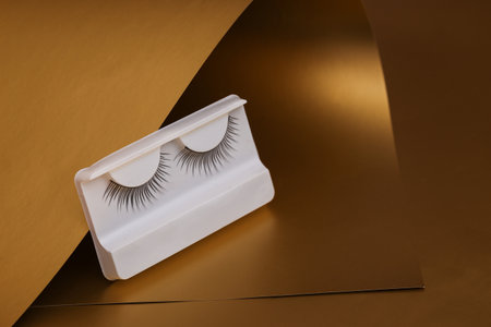 False eyelashes on a luxurious golden backgroundの写真素材