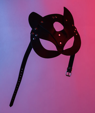 Sex shop leather cat mask floating in the air, isolated in blue-red neon gradient light. levitating objects. minimal concept. sex gamesの写真素材