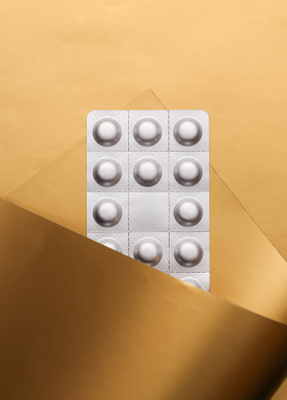 Blister pills on a luxurious golden backgroundの写真素材
