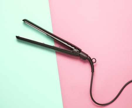 Hair straightener on pastel background. top view. minimalismの写真素材