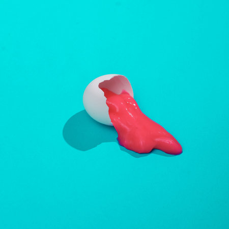 Creative layout with pink slime in broken chicken egg shell. Bright blue background with shadow....