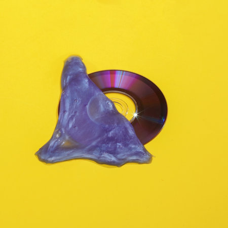 Creative layout with compact dick in slime on bright yellow background. Visual summer trend. Minimalistic retro 90s aesthetic still life with shadow. fresh ideasの写真素材