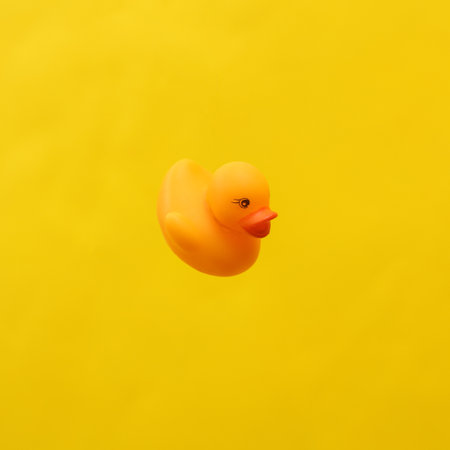 Rubber duck isolated on yellow backgroundの写真素材