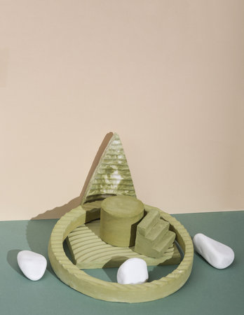Creative scene with geometric plaster shapes and pebbles on a two-tone background. Showcase for...
