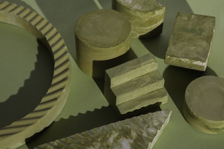 Minimal scene with plaster gypsum shapes on a green background with shadow. Geometric minimal still...