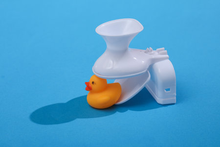 Creative layout of toilet bowl with rubber duck on bright blue background. visual trend....