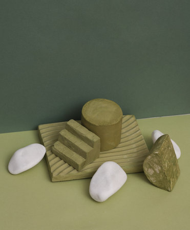 Creative scene with geometric plaster shapes and pebbles on a two-tone background. Showcase for beauty productsの写真素材