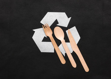 Circular recycling symbol with wooden spoon, fork and knife on black background. Eco conceptの写真素材